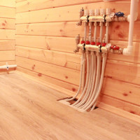 Varmvattengolv på trägolv: funktioner för att lägga systemet på en träbotten