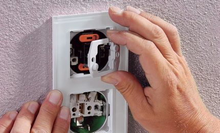 Instalación y conexión de una toma de corriente con un interruptor en una carcasa.