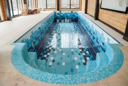 Frente a la piscina con azulejos y mosaicos.