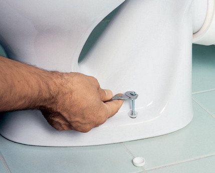 Fixing the toilet bowl with screws