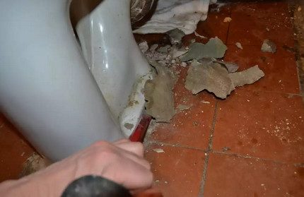Knocking down cement to remove the toilet