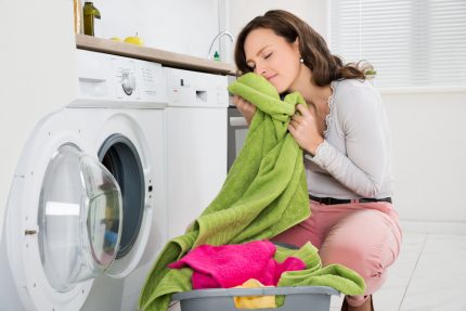 Moteris iš skalbinių išima skalbinius