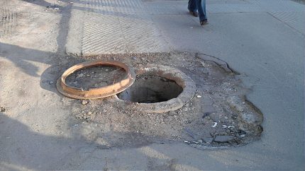 Otwórz studnię kanalizacyjną na drodze