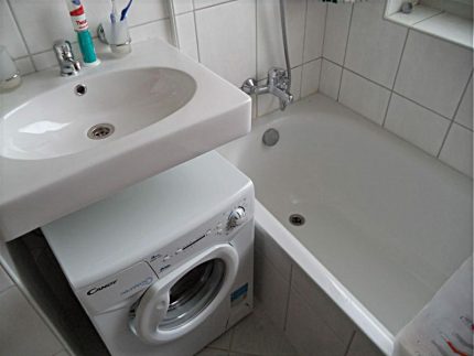 Lavandino incernierato bianco sopra la lavatrice