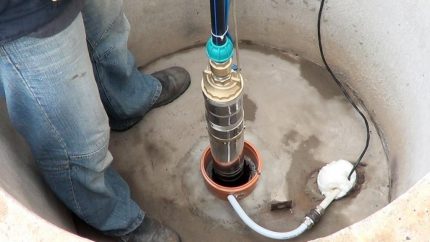 Instalación de una bomba sumergible en el tronco de un pozo.