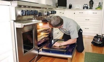 De meester repareert de oven