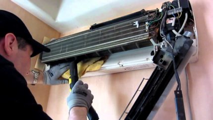Ang master ay vacuuming ang air conditioner