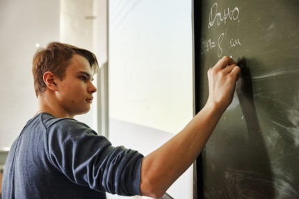 Mokinys rašo ant lentos