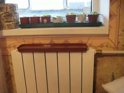 Ūdens panna uzstādīta uz radiatora